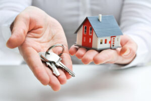 Bundaberg real estate agent holding a house and keys 